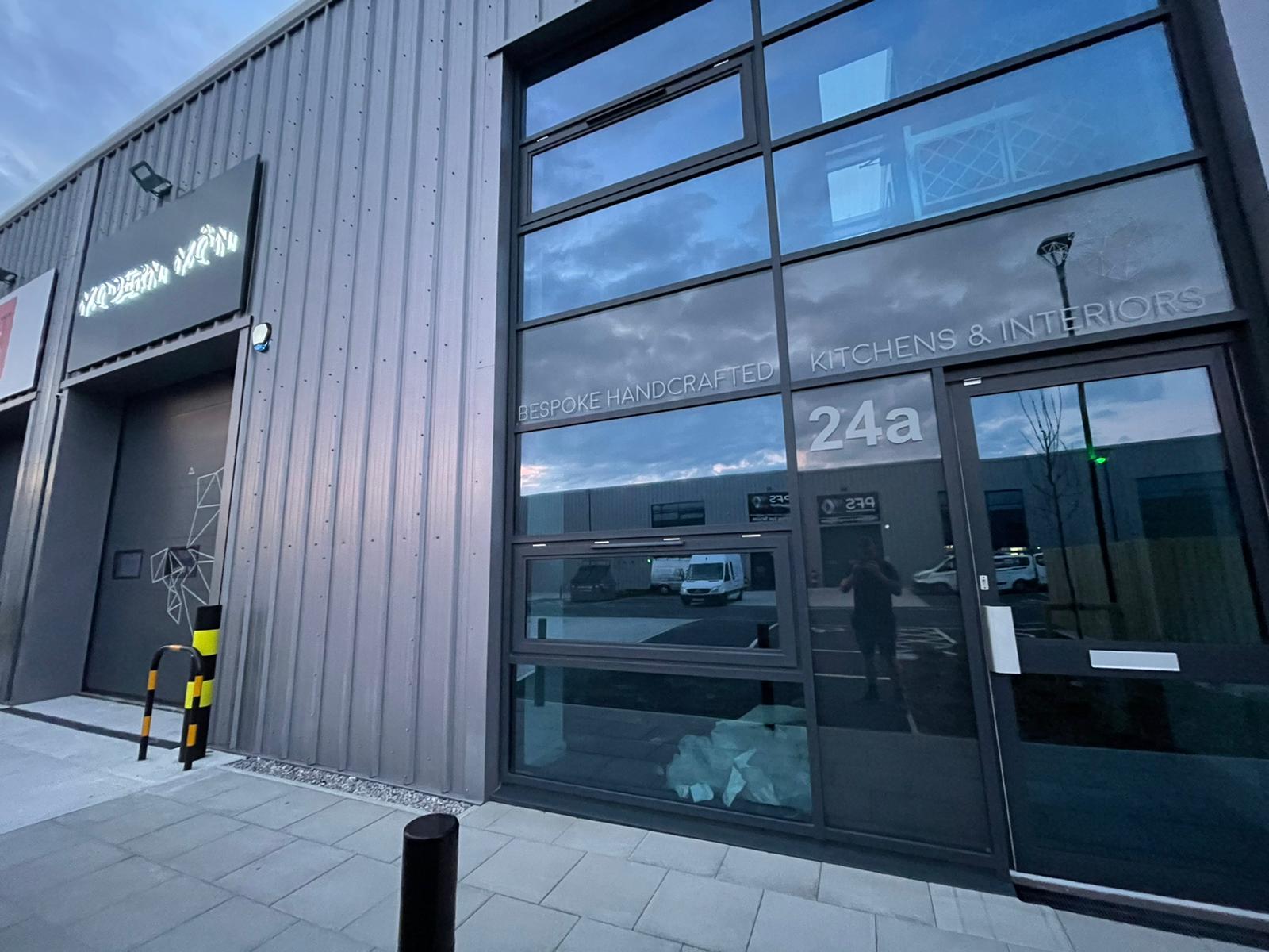 Illuminated 3D LED sign and window graphics on a showroom